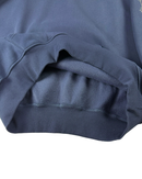 Close-up of a navy blue ribbed knit garment, showing the texture and fold of the fabric against a white background.