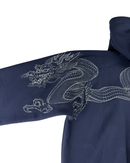 Close-up of a navy blue hooded garment with a large white embroidered dragon design across the sleeve and upper chest, shown against a plain white background.